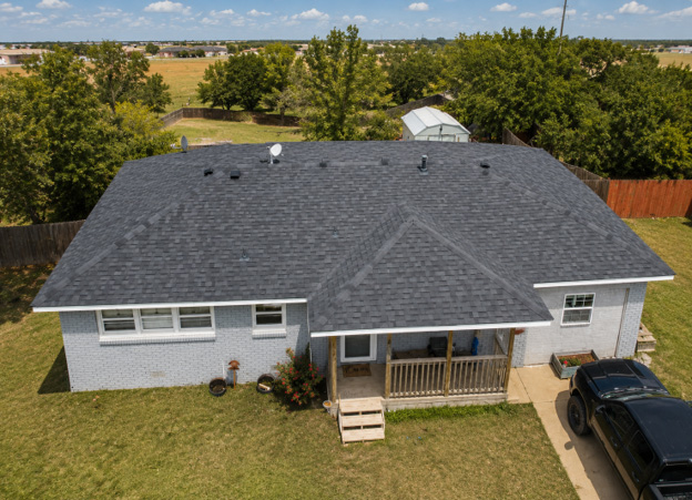 Aerial view of a refurbished residential roof with new dark shingles